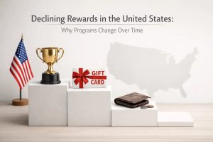 Minimalist financial scene showing a trophy, a gift card, a wallet with coins, and an American flag arranged on descending platforms, symbolizing declining rewards programs in the United States and how credit card benefits can lose value over time as programs change.